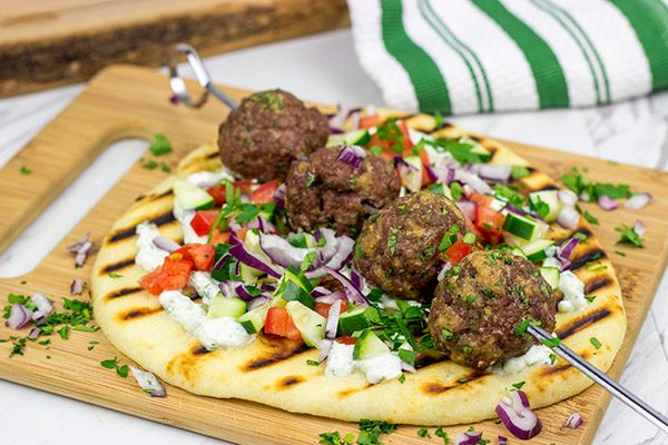 These Mediterranean Meatball Kabobs deserve a spot on your dinner menu soon!  Served up with grilled naan and a bit of tzatziki sauce, these meatballs are sure to become a favorite in your house, too!