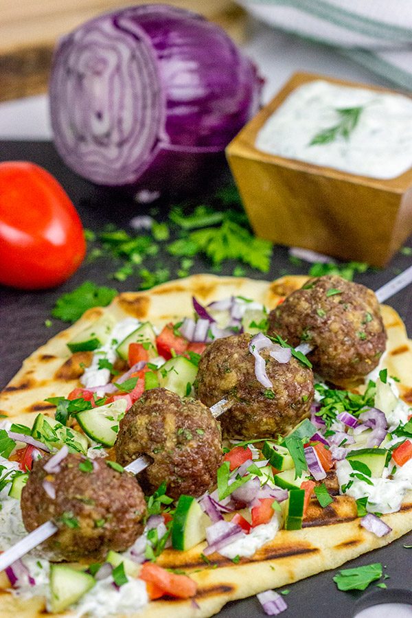 These Mediterranean Meatball Kabobs deserve a spot on your dinner menu soon!  Served up with grilled naan and a bit of tzatziki sauce, these meatballs are sure to become a favorite in your house, too!