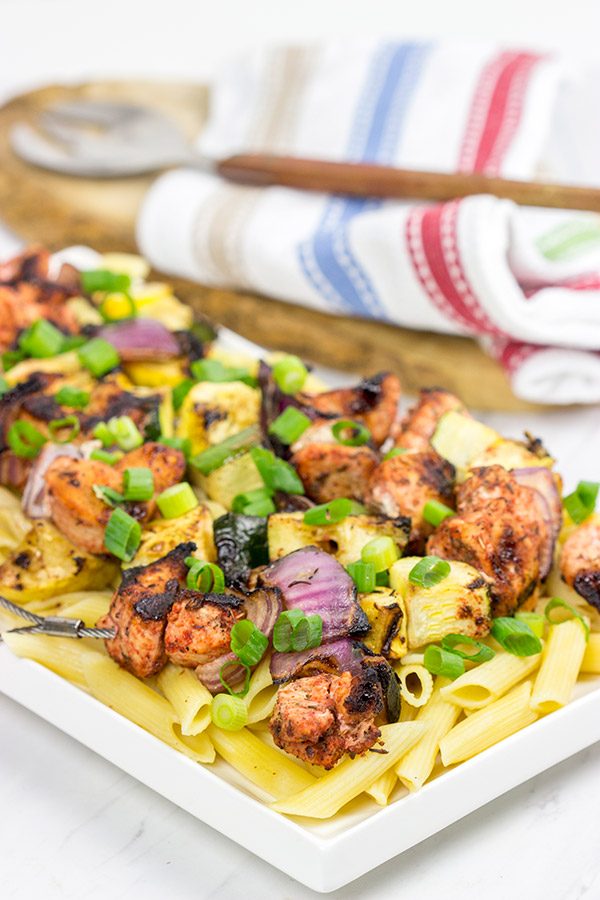 Served over pasta with a bit of grated Parmesan cheese, these Grilled Blackened Chicken Kabobs make for a tasty summer meal!