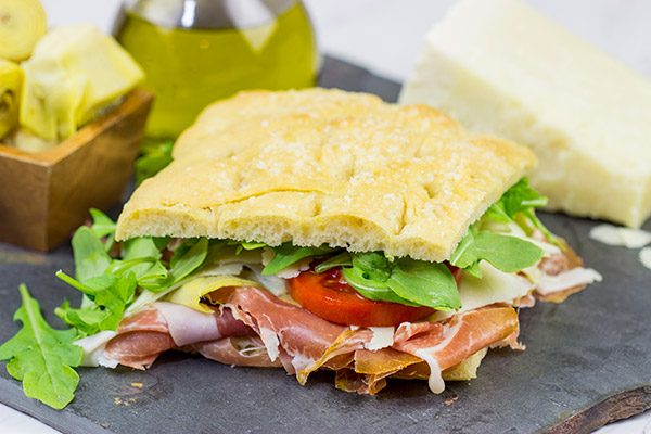 These Italian Prosciutto Panini start with a classic Tuscan bread called schiacciata.  Add in some Prosciutto di Parma, marinated artichokes and Pecorino Romano, and you've got a delicious sandwich!