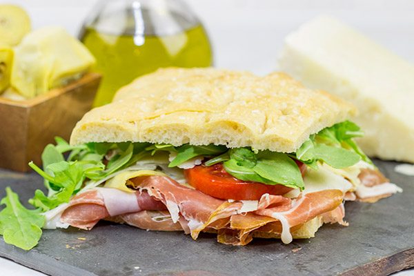 These Italian Prosciutto Panini start with a classic Tuscan bread called schiacciata.  Add in some Prosciutto di Parma, marinated artichokes and Pecorino Romano, and you've got a delicious sandwich!
