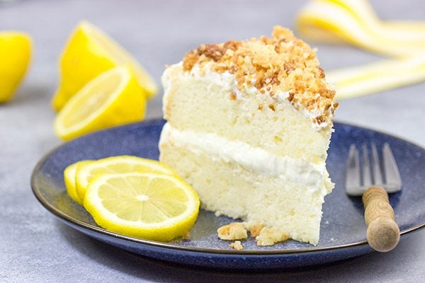 This Lemon Cream Cake features layers of delicious lemon cake topped with a light whipped frosting and crunchy crumbles!