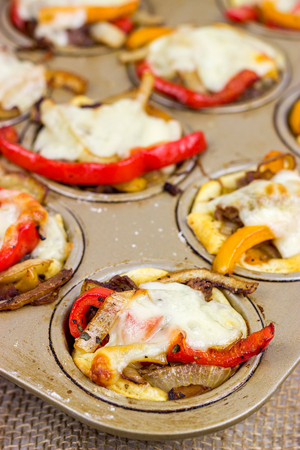 These Philly Cheesesteak Cups feature ribeye steak, peppers and onions all baked in mini crescent roll cups.  They're the perfect comfort food appetizer for football season!