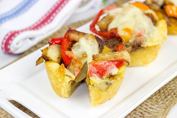 These Philly Cheesesteak Cups feature ribeye steak, peppers and onions all baked in mini crescent roll cups. They're the perfect comfort food appetizer for football season!