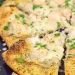 This Shrimp Scampi Pizza is the perfect football food!  Perfectly cooked shrimp combined with a flavorful garlic white sauce make this pizza a tasty option for the big game!