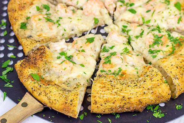 This Shrimp Scampi Pizza is the perfect football food!  Perfectly cooked shrimp combined with a flavorful garlic white sauce make this pizza a tasty option for the big game!