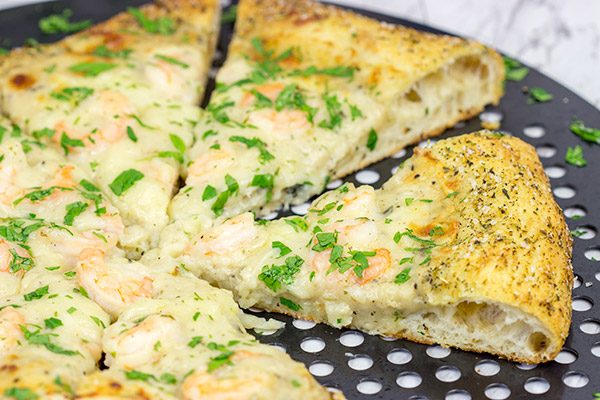 This Shrimp Scampi Pizza is the perfect football food!  Perfectly cooked shrimp combined with a flavorful garlic white sauce make this pizza a tasty option for the big game!