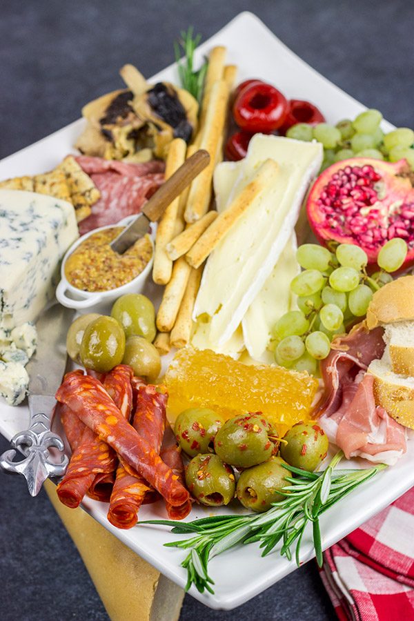 A Holiday Charcuterie Board is a great addition to any holiday party.  Here are some and tricks for turning your cheese board into the talk of the party!