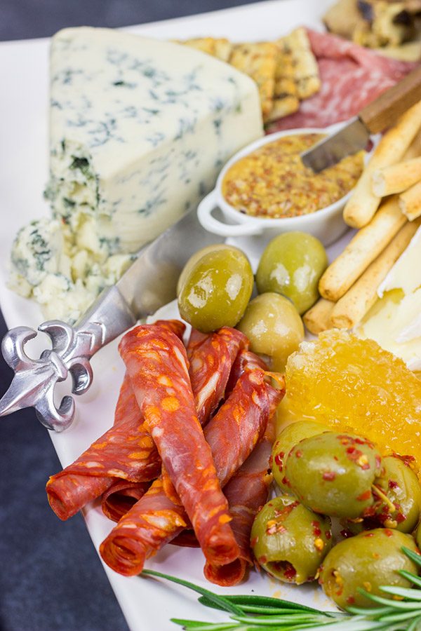 A Holiday Charcuterie Board is a great addition to any holiday party.  Here are some and tricks for turning your cheese board into the talk of the party!