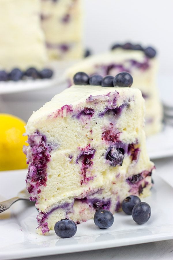 This Lemon Blueberry Cake is what happens when a muffin runs smack into the side of a cake!  Featuring muffin-like layers of cake topped with lemon cream cheese frosting, this dessert is mighty tasty!
