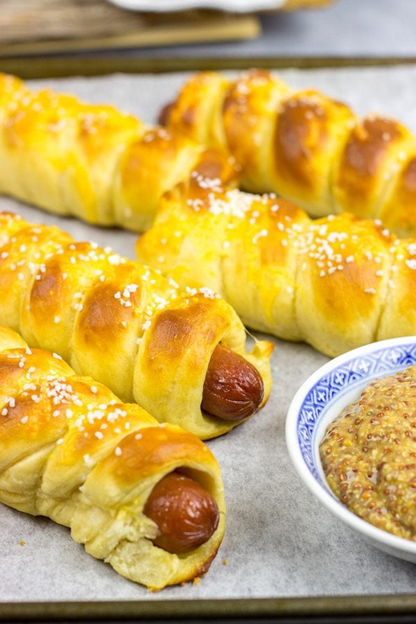 These Cheddar Pretzel Hot Dogs are wrapped with soft pretzel dough and covered with shredded cheese. Talk about a tasty way to bake up a hot dog!