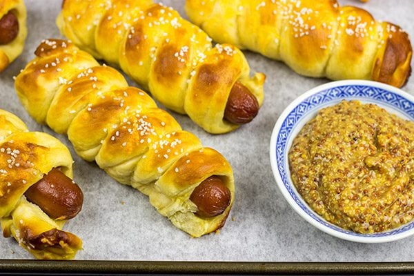These Cheddar Pretzel Hot Dogs are wrapped with soft pretzel dough and covered with shredded cheese. Talk about a tasty way to bake up a hot dog!