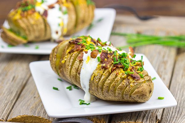These Loaded Hasselback Baked Potatoes are a fun twist on a baked potato.  Crispy edges, soft inside...and they're topped with bacon and cheese!
