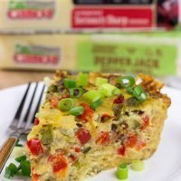 Let's do brunch the right way! This Cheesy Quiche with Hash Brown Crust is loaded with 2 types of cheese, bacon, onions and peppers. Yum!