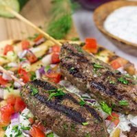 Served over grilled naan and tzatziki sauce, these Grilled Beef Kofta Kabobs are a delicious way to enjoy a summer night in the backyard!