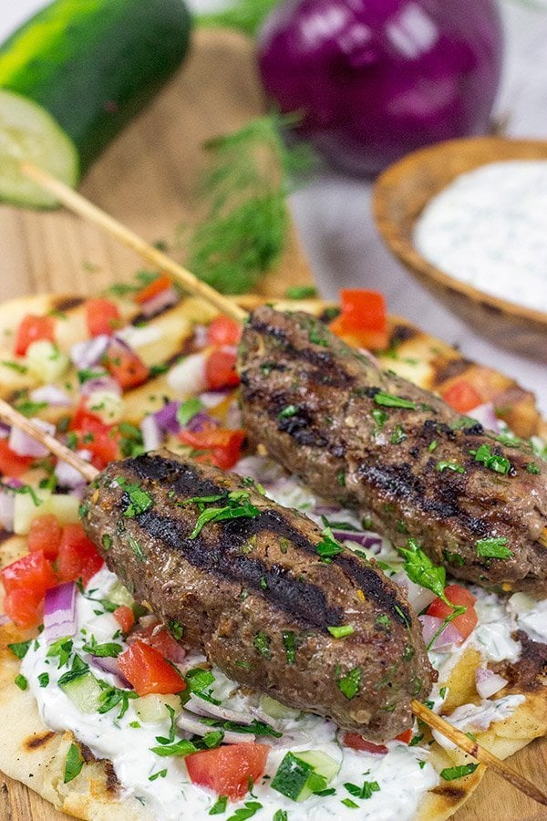 Served over grilled naan and tzatziki sauce, these Grilled Beef Kofta Kabobs are a delicious way to enjoy a summer night in the backyard!