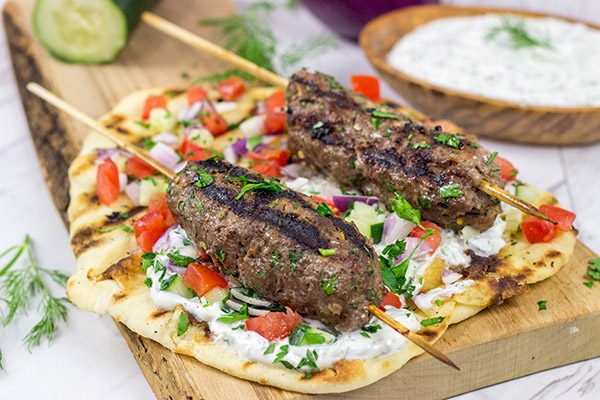Served over grilled naan and tzatziki sauce, these Grilled Beef Kofta Kabobs are a delicious way to enjoy a summer night in the backyard!