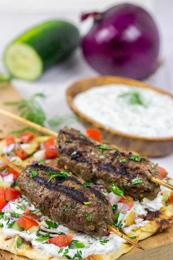 Served over grilled naan and tzatziki sauce, these Grilled Beef Kofta Kabobs are a delicious way to enjoy a summer night in the backyard!