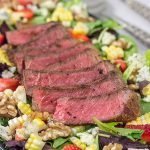 Grilling season is back!  Let's kick it off with a delicious Grilled Steak Salad topped with strawberries, blue cheese, corn and toasted walnuts!