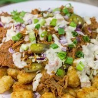 Kick off BBQ season the right way! These Pulled Pork Totchos are topped with pulled pork, cole slaw and pepper jack queso. This delicious appetizer will be the hit of the party!