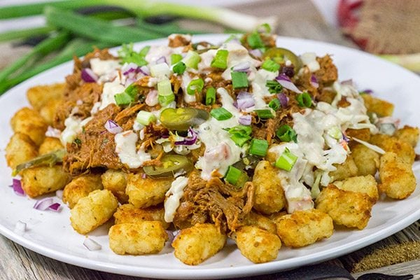 Kick off BBQ season the right way! These Pulled Pork Totchos are topped with pulled pork, cole slaw and pepper jack queso. This delicious appetizer will be the hit of the party!