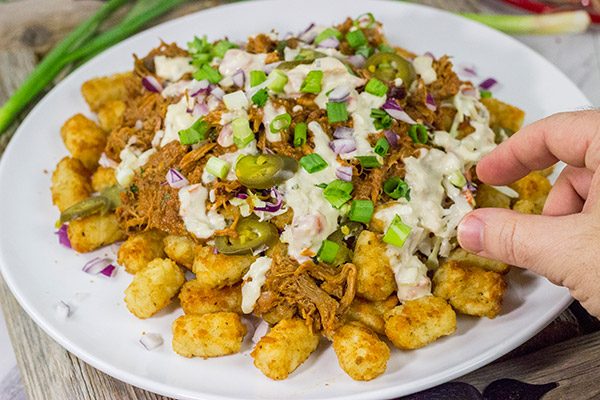 Kick off BBQ season the right way! These Pulled Pork Totchos are topped with pulled pork, cole slaw and pepper jack queso. This delicious appetizer will be the hit of the party!