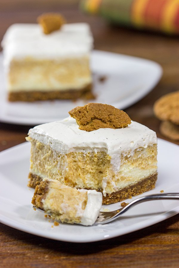 These Pumpkin Swirl Cheesecake Bars feature creamy cheesecake topped with a vanilla bean whipped cream...all over a gingersnap crust!  Talk about the perfect Autumn dessert!