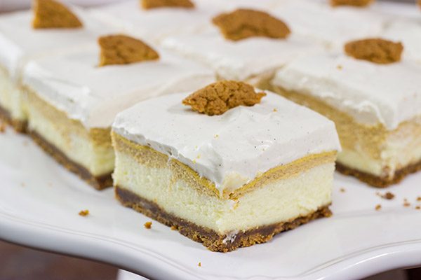 These Pumpkin Swirl Cheesecake Bars feature creamy cheesecake topped with a vanilla bean whipped cream...all over a gingersnap crust! Talk about the perfect Autumn dessert!