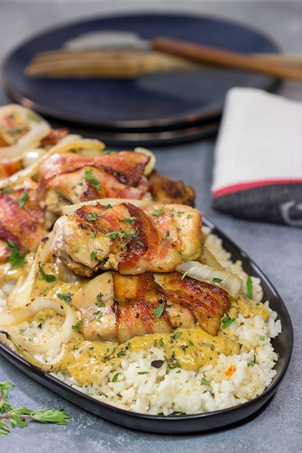 These Bacon-Wrapped Chicken Thighs are served over seasoned rice with a Dijon cream sauce.  Sounds fancy, right?  But this recipe came out of your own kitchen!