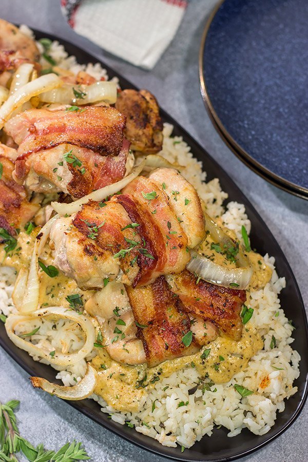 These Bacon-Wrapped Chicken Thighs are served over seasoned rice with a Dijon cream sauce. Sounds fancy, right? But this recipe came out of your own kitchen!