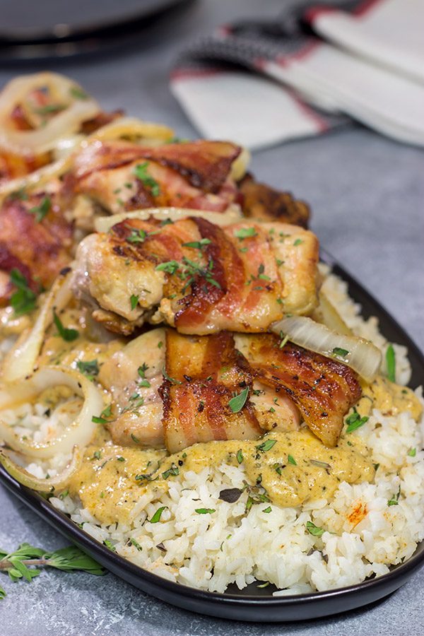 These Bacon-Wrapped Chicken Thighs are served over seasoned rice with a Dijon cream sauce. Sounds fancy, right? But this recipe came out of your own kitchen!
