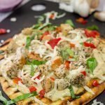 This Grilled Chicken Flatbread features juicy chunks of chicken over a roasted garlic sauce.  Served on tasty naan or flatbread, this recipe will have you coming back for more!