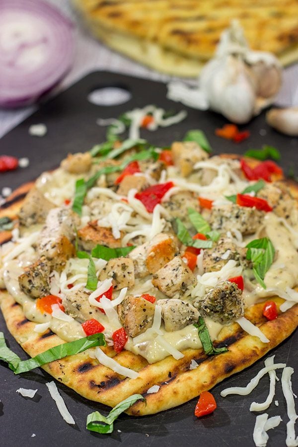 This Grilled Chicken Flatbread features juicy chunks of chicken over a roasted garlic sauce. Served on tasty naan or flatbread, this recipe will have you coming back for more!