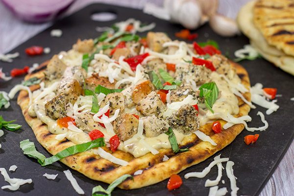 This Grilled Chicken Flatbread features juicy chunks of chicken over a roasted garlic sauce.  Served on tasty naan or flatbread, this recipe will have you coming back for more!