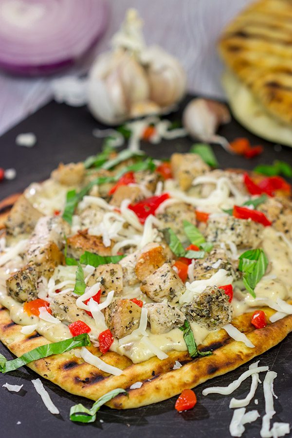 This Grilled Chicken Flatbread features juicy chunks of chicken over a roasted garlic sauce.  Served on tasty naan or flatbread, this recipe will have you coming back for more!