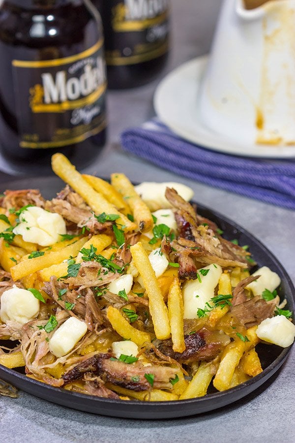 North meets South in this tasty Pulled Pork Poutine recipe. French fries topped with cheese curds, brown gravy and slow-smoked pulled pork make for a delicious appetizer or meal!