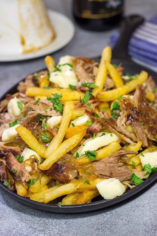 North meets South in this tasty Pulled Pork Poutine recipe. French fries topped with cheese curds, brown gravy and slow-smoked pulled pork make for a delicious appetizer or meal!