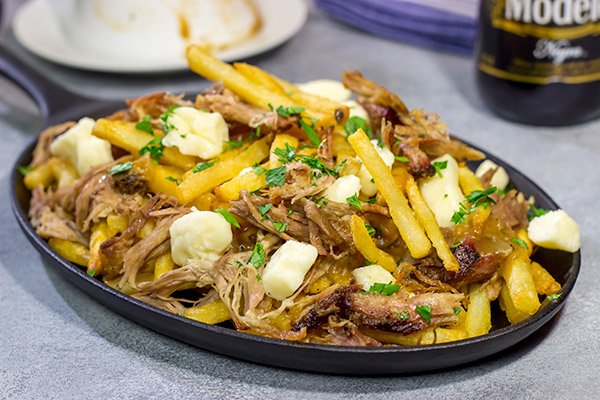 North meets South in this tasty Pulled Pork Poutine recipe. French fries topped with cheese curds, brown gravy and slow-smoked pulled pork make for a delicious appetizer or meal!