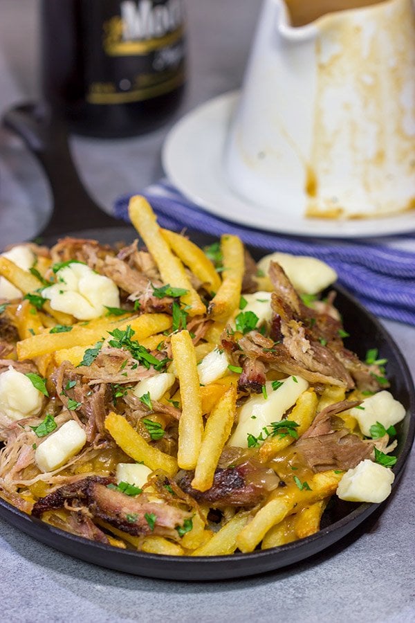 North meets South in this tasty Pulled Pork Poutine recipe. French fries topped with cheese curds, brown gravy and slow-smoked pulled pork make for a delicious appetizer or meal!