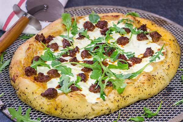 Mix up pizza night!  This Italian Sausage and Alfredo Pizza features a delicious alfredo sauce base topped with juicy Italian sausage and fresh arugula!