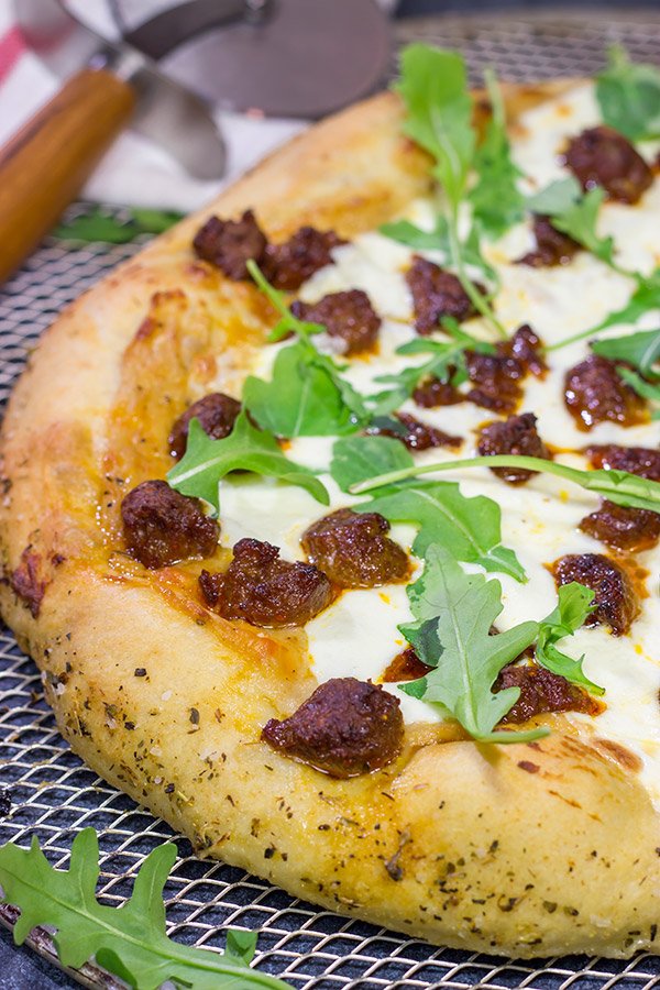 Mix up pizza night!  This Italian Sausage and Alfredo Pizza features a delicious alfredo sauce base topped with juicy Italian sausage and fresh arugula!