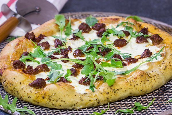 Mix up pizza night!  This Italian Sausage and Alfredo Pizza features a delicious alfredo sauce base topped with juicy Italian sausage and fresh arugula!