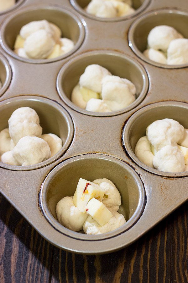 Take a good garlic knot and make it better...by adding cheese!  These Cheesy Muffin Tin Garlic Knots are a fun and tasty snack.  They're sure to become a family favorite!