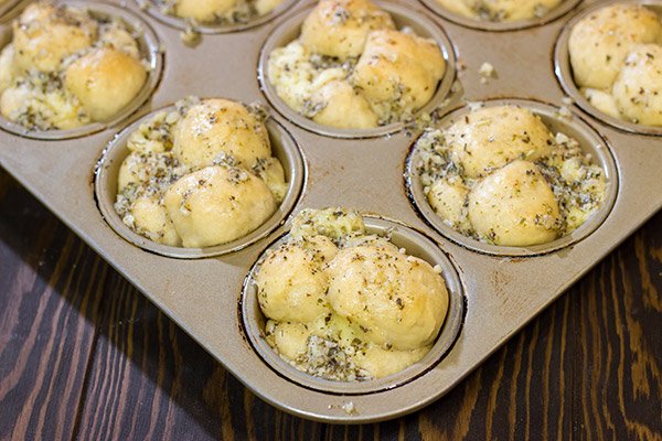 Take a good garlic knot and make it better...by adding cheese!  These Cheesy Muffin Tin Garlic Knots are a fun and tasty snack.  They're sure to become a family favorite!