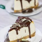 Topped with melted chocolate and chopped Andes mints, this Ricotta Cheesecake with Peppermint Chocolate Sauce is a delicious and fun holiday dessert!