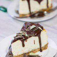 Topped with melted chocolate and chopped Andes mints, this Ricotta Cheesecake with Peppermint Chocolate Sauce is a delicious and fun holiday dessert!