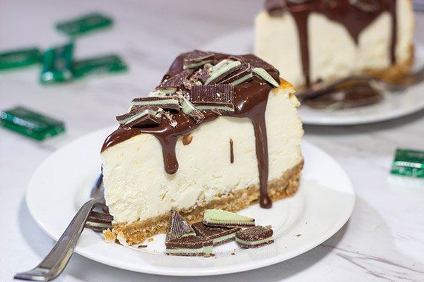 Topped with melted chocolate and chopped Andes mints, this Ricotta Cheesecake with Peppermint Chocolate Sauce is a delicious and fun holiday dessert!