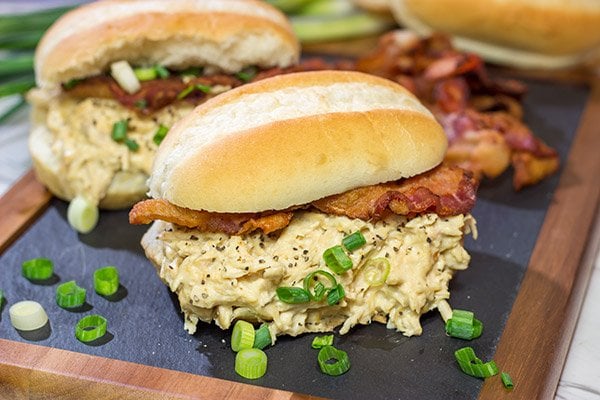 Creamy, shredded chicken topped with crunchy bacon = delicious.  These Slow Cooker Crack Chicken Sandwiches are an easy and delicious recipe!