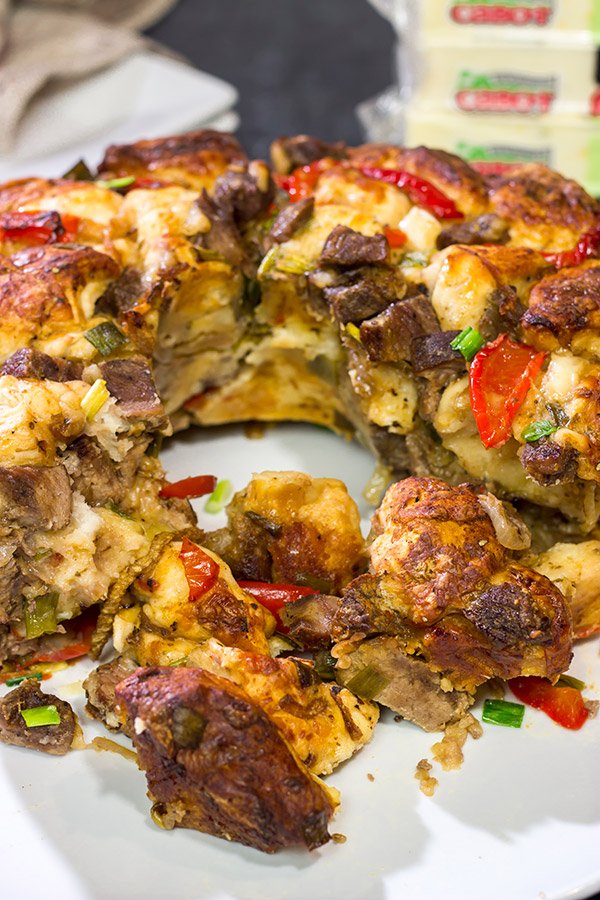 Packed with juicy steak, sauteed peppers + onions and two types of cheese, this Philly Cheesesteak Monkey Bread is one delicious way to mix up the routine!