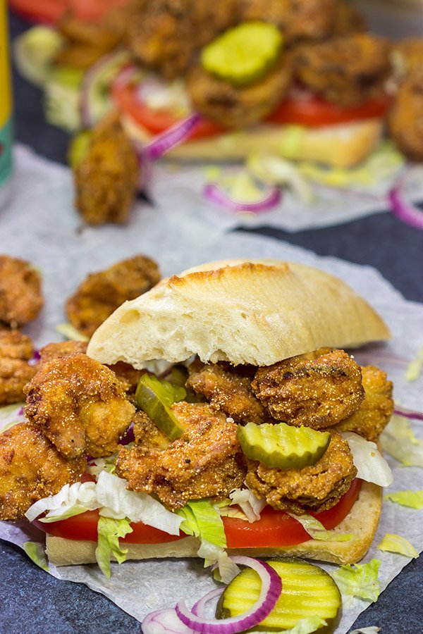 These Fried Shrimp Po'boys are a classic Louisiana sandwich!  A hunk of French bread topped with Cajun fried shrimp, creamy remoulade sauce and shredded lettuce is hard to beat!